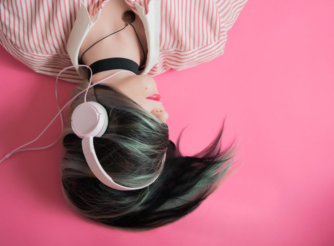 A woman lying down listening thru headphone