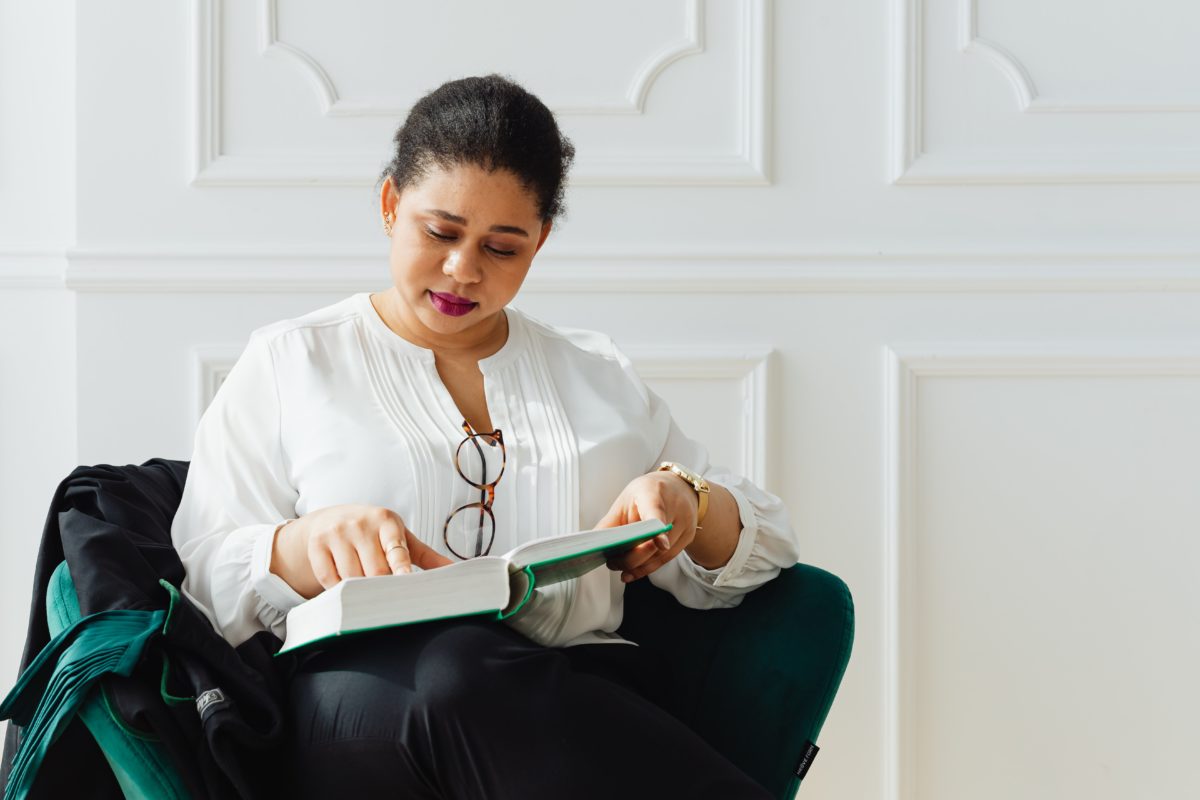 A middle-aged woman sits reading a book